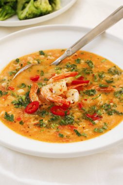 Beyaz tabakta karides ile bol domates çorbası