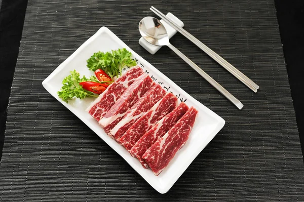 Carne fresca en rodajas con comino y chile en bandeja blanca — Foto de Stock