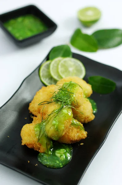 Fried chicken balls with lime sauce on black platter — Stock Photo, Image
