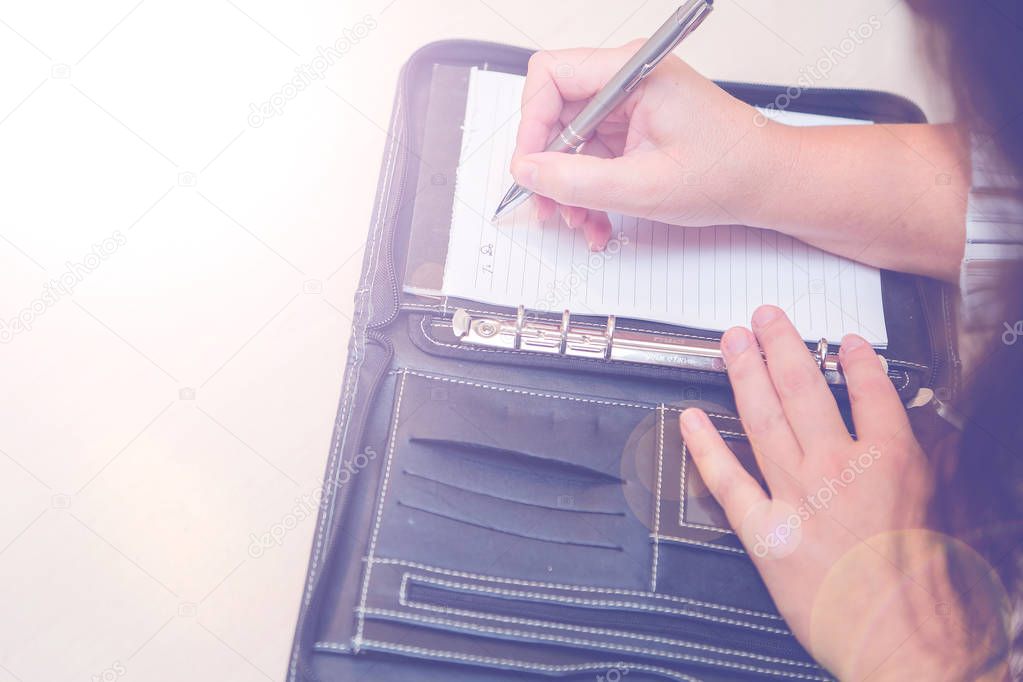 Woman writing on notepad