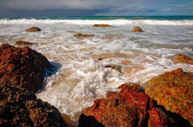 Port Macquarie Avustralya, kum plajındaki büyük kaya oluşumları