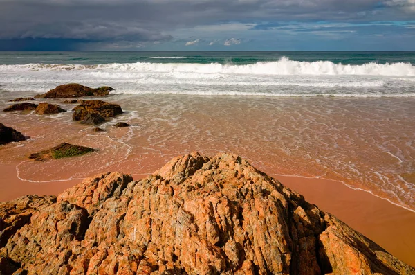 Large rock formations on sandy beach at Port Macquarie Australia