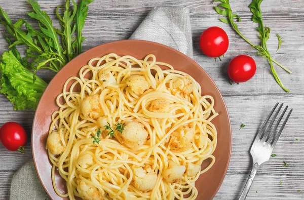 Espaguetis de pasta italiana sobre plato marrón con coliflor Imagen De Stock