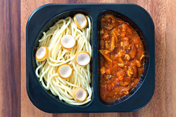 Plastik bir kutu içinde kırmızı domates soslu spagetti