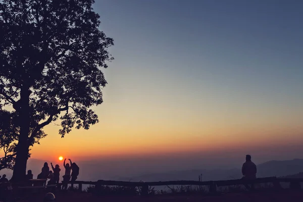 Povos e árvores silhuetas com o pôr do sol deslumbrante — Fotografia de Stock