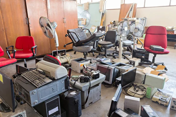 Broken office chairs and electronic waste in the store room