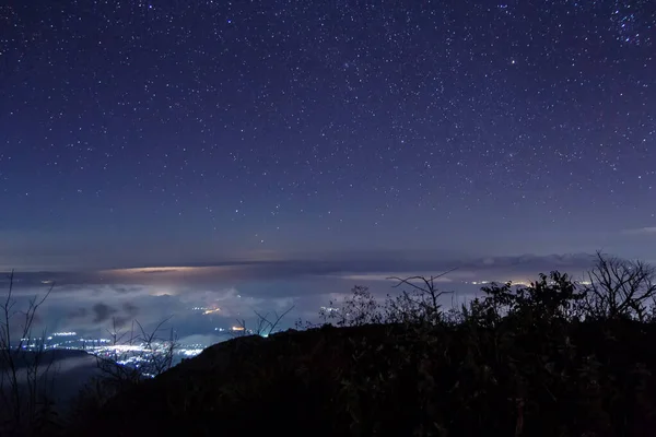 雲と山の上の星と夜景 — ストック写真