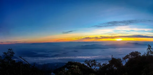 夜明けに山を覆う霧と霧と雲の日の出のパノラマ — ストック写真