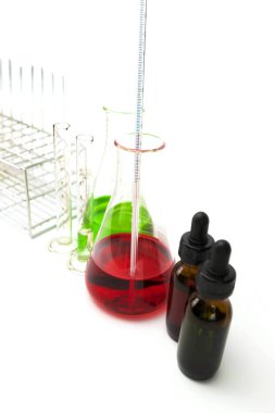 Alt ve beher kabı beyazda izole edilmiş. Mataradaki birkaç kimyasal çözelti. Laboratuvar camları.