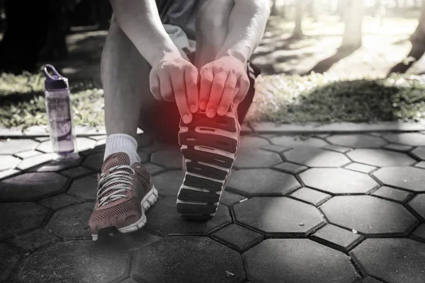 Asian athletes are stretching his legs before running work out o