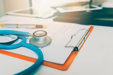 Masanın üzerinde steteskop ve kağıt pano yakın plan.
