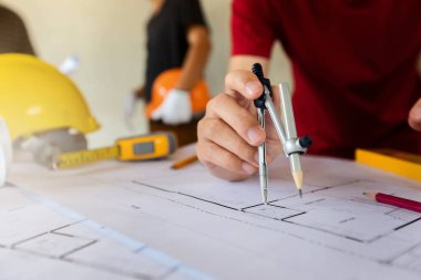 Bir mimar veya mühendis planı üzerinde çalışan, bir mimar veya mühendis plan üzerinde bir bölücü ölçer kullanır., mimari kavram