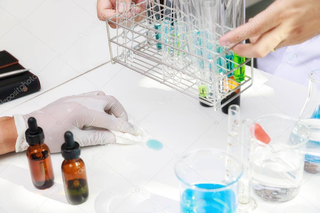 Researcher or scientists clean chemicals spilled onto the table in laboratory.