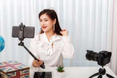 Genç Asyalı kadın blogcu, video kaydını canlı yayınlarken akıllı telefonuyla selfie çekiyor. blog yazarı ve vlogger sosyal medya kavramı üzerinde çevrimiçi etkileyiciName.