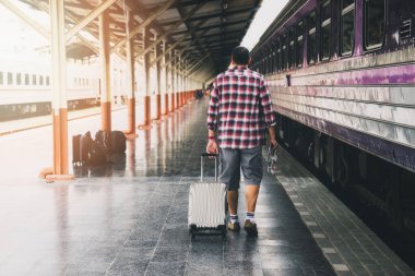 Tren istasyonunda bagajı ve haritası olan bir gezgin. Seyahat kavramı.