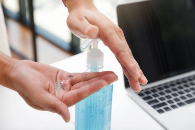 İşe gitmeden önce el temizlemek için alkol bazlı el dezenfektanı kullanan bir adam. Anti bakteri ve Koronavirüs Hastalığı 2019 (COVID-19) virüs salgınlarından korunma.