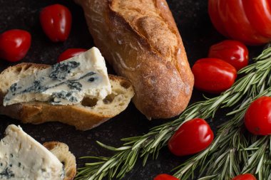 Mavi peynir ile Fransız baget, domates ve siyah mermer masa üzerinde otlar. Fransa ve İtalya geleneksel aperatifler