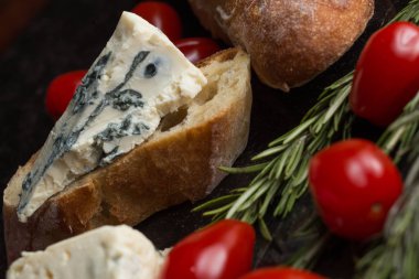 Mavi peynir ile Fransız baget, domates ve siyah mermer masa üzerinde otlar. Fransa ve İtalya geleneksel aperatifler