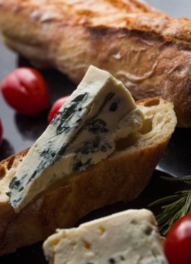 Mavi peynir ile Fransız baget, domates ve siyah mermer masa üzerinde otlar. Fransa ve İtalya geleneksel aperatifler