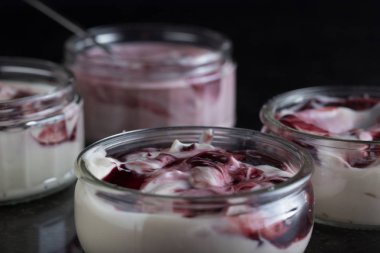 Yoğurt karanlık mermer arka plan üzerinde karışım cam kase meyve ile. Doğal ve sağlıklı meyve, diyet, gurme tatlı granola kahvaltı için. Tatlı yoğurt portre