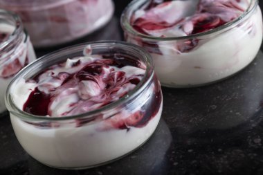 Yoğurt karanlık mermer arka plan üzerinde karışım cam kase meyve ile. Doğal ve sağlıklı meyve, diyet, gurme tatlı granola kahvaltı için. Tatlı yoğurt portre