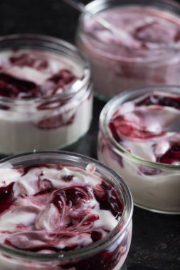 Yoğurt karanlık mermer arka plan üzerinde karışım cam kase meyve ile. Doğal ve sağlıklı meyve, diyet, gurme tatlı granola kahvaltı için. Tatlı yoğurt portre