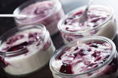 Yoğurt karanlık mermer arka plan üzerinde karışım cam kase meyve ile. Doğal ve sağlıklı meyve, diyet, gurme tatlı granola kahvaltı için. Tatlı yoğurt portre