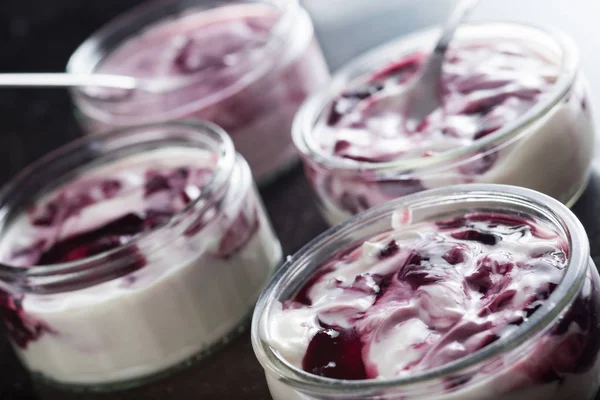 Yoğurt karanlık mermer arka plan üzerinde karışım cam kase meyve ile. Doğal ve sağlıklı meyve, diyet, gurme tatlı granola kahvaltı için. Tatlı yoğurt portre