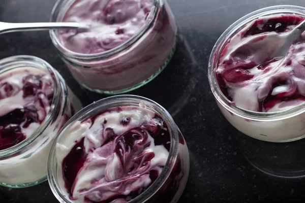 Yoğurt karanlık mermer arka plan üzerinde karışım cam kase meyve ile. Doğal ve sağlıklı meyve, diyet, gurme tatlı granola kahvaltı için. Tatlı yoğurt portre