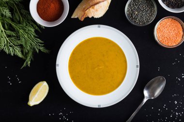 Krem çeşitli mercimek çorbası. Sarı ve yeşil lens, baharat olarak çiğ yemek ve limon siyah backgraund üzerinde. Sağlıklı, lezzetli, lezzetli, vejetaryen yemek. Üstten Görünüm, kopya alanı