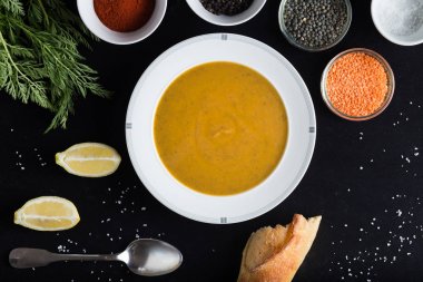 Krem çeşitli mercimek çorbası. Sarı ve yeşil lens, baharat olarak çiğ yemek ve limon siyah backgraund üzerinde. Sağlıklı, lezzetli, lezzetli, vejetaryen yemek. Üstten Görünüm, kopya alanı