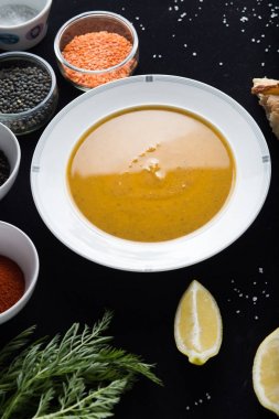 Krem çeşitli mercimek çorbası. Sarı ve yeşil lens, baharat olarak çiğ yemek ve limon siyah backgraund üzerinde. Sağlıklı, lezzetli, lezzetli, vejetaryen yemek. Üstten Görünüm, kopya alanı