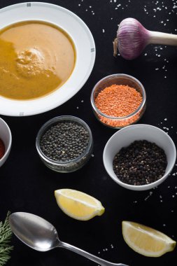 Krem çeşitli mercimek çorbası. Sarı ve yeşil lens, baharat olarak çiğ yemek ve limon siyah backgraund üzerinde. Sağlıklı, lezzetli, lezzetli, vejetaryen yemek. Üstten Görünüm, kopya alanı