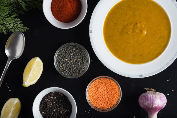 Krem çeşitli mercimek çorbası. Sarı ve yeşil lens, baharat olarak çiğ yemek ve limon siyah backgraund üzerinde. Sağlıklı, lezzetli, lezzetli, vejetaryen yemek. Üstten Görünüm, kopya alanı