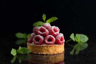 Ahududulu tart tatlı koyu arka plan üzerinde. Geleneksel Fransız tatlı pasta. Lezzetli, iştah açıcı, ev yapımı Pasta krema, taze meyveler ve meyve ile. Alan, closeup kopyalayın. Seçici odak