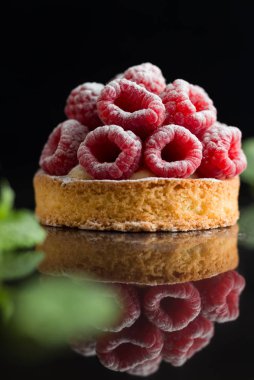 Ahududulu tart tatlı koyu arka plan üzerinde. Geleneksel Fransız tatlı pasta. Lezzetli, iştah açıcı, ev yapımı Pasta krema, taze meyveler ve meyve ile. Alan, closeup kopyalayın. Seçici odak