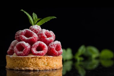 Ahududulu tart tatlı koyu arka plan üzerinde. Geleneksel Fransız tatlı pasta. Lezzetli, iştah açıcı, ev yapımı Pasta krema, taze meyveler ve meyve ile. Alan, closeup kopyalayın. Seçici odak