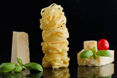 Makarna Tagliatelle, parmesan mermer masaya düzenlenmiştir. Geleneksel İtalyan mutfağı yemek için lezzetli kuru pişmemiş maddeler. Ham closeup arka plan. Üstten Görünüm. Kopya alanı