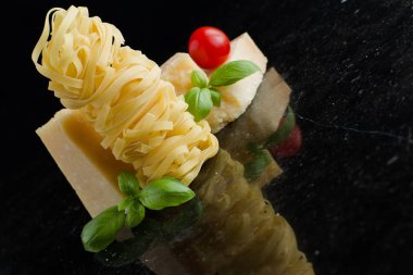 Makarna Tagliatelle, parmesan mermer masaya düzenlenmiştir. Geleneksel İtalyan mutfağı yemek için lezzetli kuru pişmemiş maddeler. Ham closeup arka plan. Üstten Görünüm. Kopya alanı