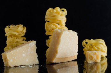 Makarna Tagliatelle, parmesan mermer masaya düzenlenmiştir. Geleneksel İtalyan mutfağı yemek için lezzetli kuru pişmemiş maddeler. Ham closeup arka plan. Üstten Görünüm. Kopya alanı
