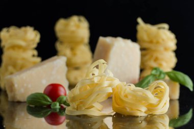 Makarna Tagliatelle, parmesan mermer masaya düzenlenmiştir. Geleneksel İtalyan mutfağı yemek için lezzetli kuru pişmemiş maddeler. Ham closeup arka plan. Üstten Görünüm. Kopya alanı