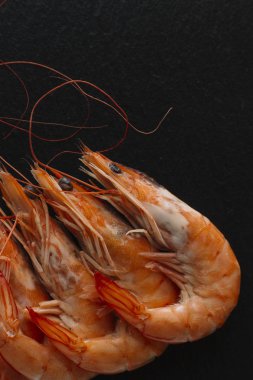 Siyah arka plan üzerine karides. Lezzetli deniz ürünleri meze haşlama veya ızgara baharatlar ile servis. Yakın çekim. Üstten Görünüm