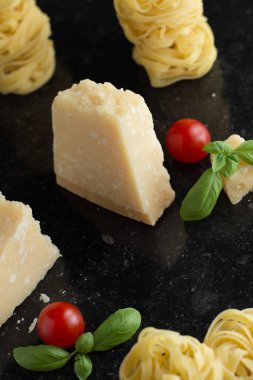 Makarna Tagliatelle, parmesan mermer masaya düzenlenmiştir. Geleneksel İtalyan mutfağı yemek için lezzetli kuru pişmemiş maddeler. Ham closeup arka plan. Üstten Görünüm. Kopya alanı