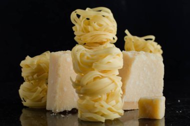 Makarna Tagliatelle, parmesan mermer masaya düzenlenmiştir. Geleneksel İtalyan mutfağı yemek için lezzetli kuru pişmemiş maddeler. Ham closeup arka plan. Üstten Görünüm. Kopya alanı