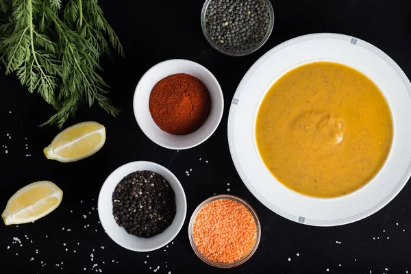 Krem çeşitli mercimek çorbası. Sarı ve yeşil lens, baharat olarak çiğ yemek ve limon siyah backgraund üzerinde. Sağlıklı, lezzetli, lezzetli, vejetaryen yemek. Üstten Görünüm, kopya alanı