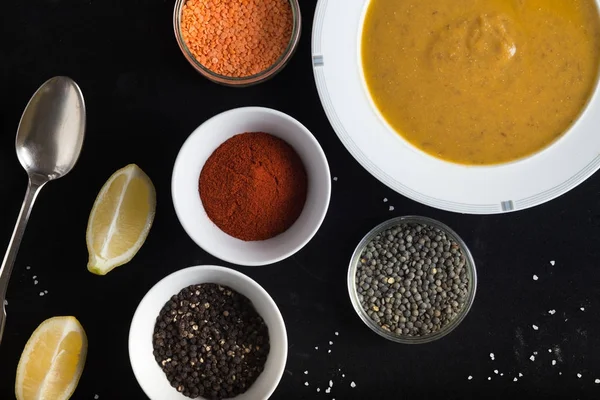 Krem çeşitli mercimek çorbası. Sarı ve yeşil lens, baharat olarak çiğ yemek ve limon siyah backgraund üzerinde. Sağlıklı, lezzetli, lezzetli, vejetaryen yemek. Üstten Görünüm, kopya alanı
