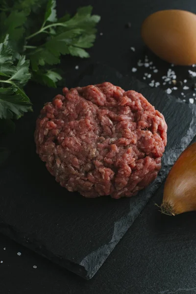 Çiğ biftek. Sığır eti çiğ et baharat, ot ve yumurta sarısı ile kıyılmış. Taze, baharatlı, lezzetli, gurme yemek ile kopya alanı, koyu arka plan üzerinde yakın çekim.