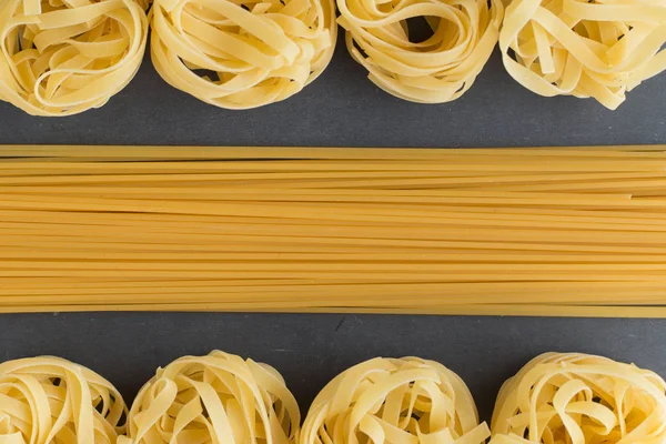 Makarna ham closeup arka plan çeşitli karışımı. Geleneksel İtalyan mutfağı yemek için lezzetli kuru pişmemiş madde. Çeşitli şekiller dokulu. Üstten Görünüm. Kopya alanı