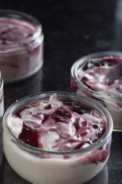 Yoğurt karanlık mermer arka plan üzerinde karışım cam kase meyve ile. Doğal ve sağlıklı meyve, diyet, gurme tatlı granola kahvaltı için. Tatlı yoğurt portre