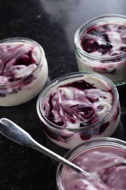 Yoğurt karanlık mermer arka plan üzerinde karışım cam kase meyve ile. Doğal ve sağlıklı meyve, diyet, gurme tatlı granola kahvaltı için. Tatlı yoğurt portre